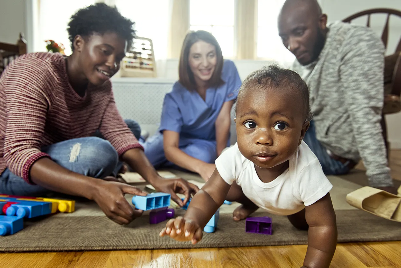 Family, nurse, and baby playing